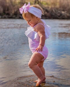 Simple Life Pattern Company | Baby Elise's One Shoulder Swimsuit & Tankini. Downloadable PDF Sewing Pattern for Baby Sizes Newborn to 24 Months. Baby Elise's One Shoulder swimsuit can be sewn as a one piece or a tankini.  Both versions can feature the optional flounce and skinny strap or be left as a simple single shoulder suit.  The tankini also has an optional circle skirt for the ultimate girly swimsuit.  Fully lined or partial lining.  A shorten/lengthen line is included for the perfect fit and coverage you may want.  If you prefer a one piece for more sun coverage, we have included an optional snap crotch panel for easy diaper changes.